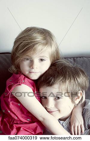 Stock Photo - Young brother and sister embracing, portrait. Fotosearch