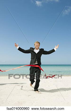 Young businessman running on beach towards finishing line View Large Photo Image Stock Image - Young businessman running on beach towards finishing line. Fotosearch