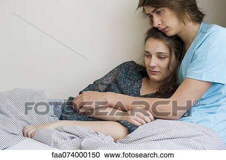 Young couple relaxing together under blanket View Large Photo Image Stock Image - Young couple relaxing together under blanket. Fotosearch