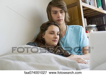 Stock Photo - Young couple relaxing together with laptop computer. Fotosearch