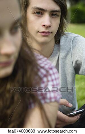 Young man holding text phone, portrait View Large Photo Image Stock Image - Young man holding text phone, portrait. Fotosearch