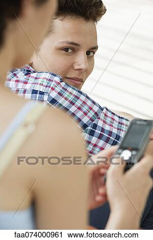 Young man looking over shoulder at camera View Large Photo Image Stock Image - Young man looking over shoulder at camera. Fotosearch