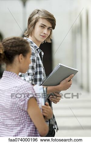 Young man on university campus View Large Photo Image Stock Photograph - Young man on university campus. Fotosearch