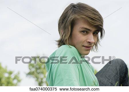 Young man relaxing outdoors, portrait View Large Photo Image Stock Photography - Young man relaxing outdoors, portrait. Fotosearch