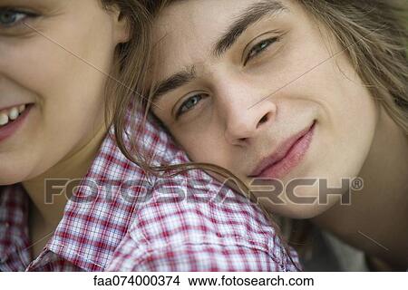 Picture - Young man resting head on girlfriend's shoulder, cropped portrait. Fotosearch