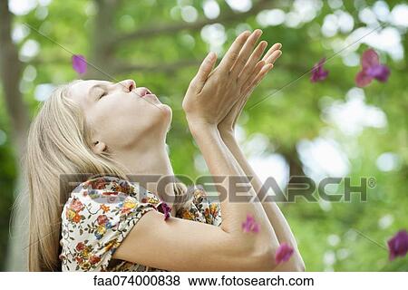 Young woman blowing purple flowers View Large Photo Image Stock Photo - Young woman blowing purple flowers. Fotosearch