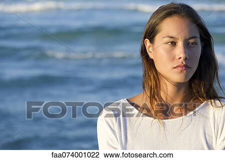 Stock Image - Young woman by sea, portrait. Fotosearch