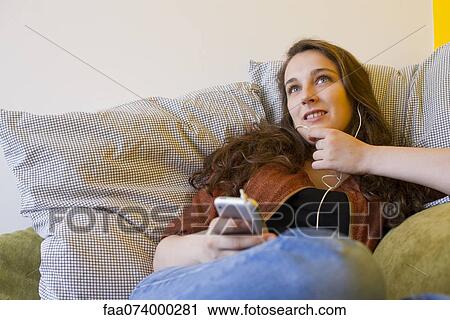 Young woman listening to MP3 player View Large Photo Image Stock Image - Young woman listening to MP3 player. Fotosearch
