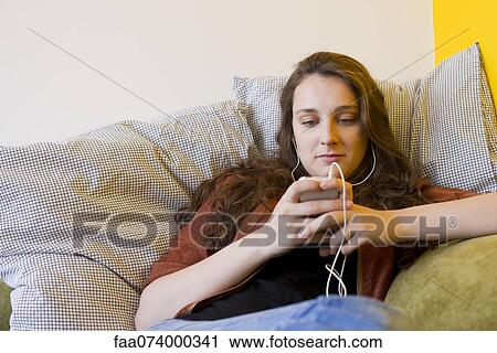 Young woman listening to MP3 player View Large Photo Image Stock Image - Young woman listening to MP3 player. Fotosearch