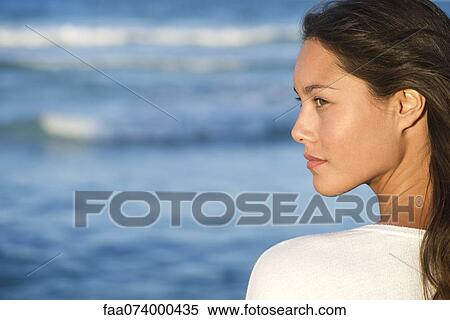 Stock Photography - Young woman looking at ocean view, profile. Fotosearch