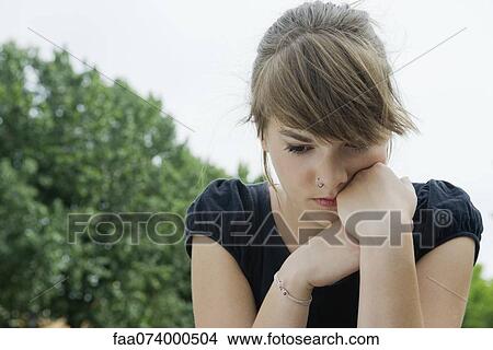 Young woman looking down in thought View Large Photo Image Picture - Young woman looking down in thought. Fotosearch