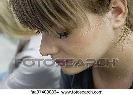 Picture - Young woman looking down in thought. Fotosearch