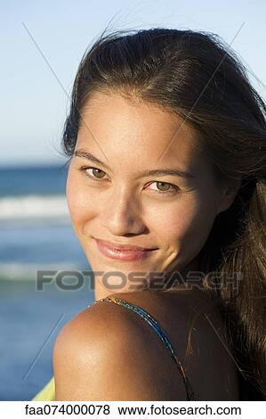Young woman looking over shoulder, portrait View Large Photo Image Stock Photo - Young woman looking over shoulder, portrait. Fotosearch