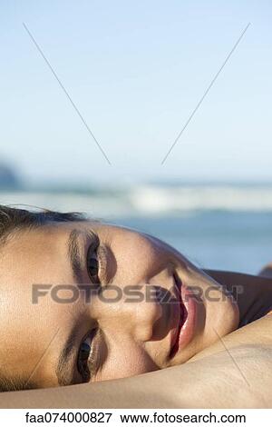Stock Photo - Young woman lying down, cropped. Fotosearch