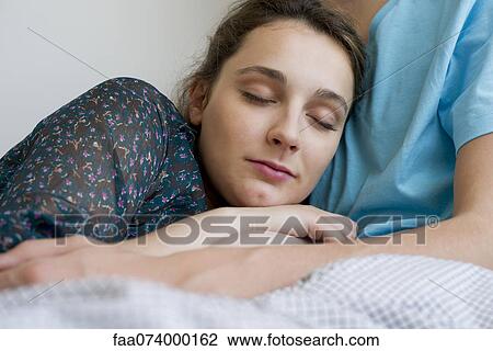 Young woman napping with head resting on man's chest View Large Photo Image Stock Image - Young woman napping with head resting on man's chest. Fotosearch