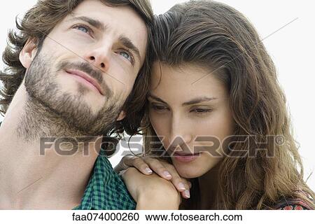 Stock Image - Young woman putting hands on young man's shoulder. Fotosearch