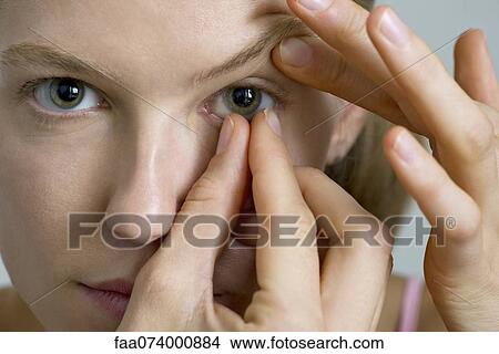 Young woman putting in contact lens View Large Photo Image Picture - Young woman putting in contact lens. Fotosearch