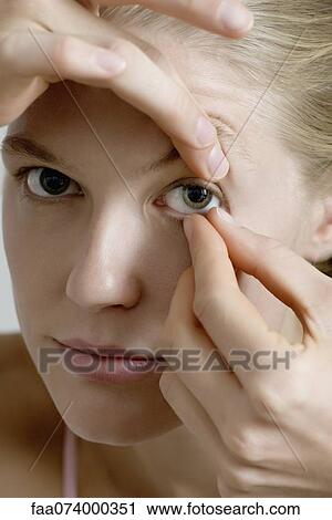 Young woman putting in contact lens View Large Photo Image Stock Image - Young woman putting in contact lens. Fotosearch