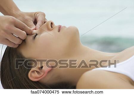 Stock Photography - Young woman receiving face massage, side view. Fotosearch