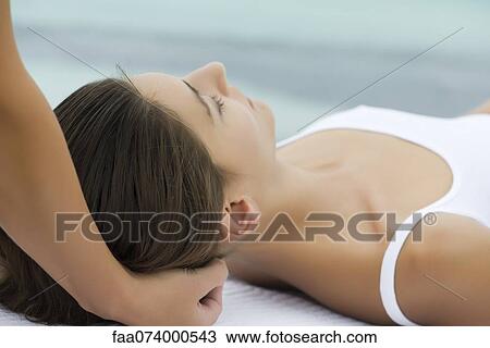 Stock Image - Young woman receiving head massage. Fotosearch