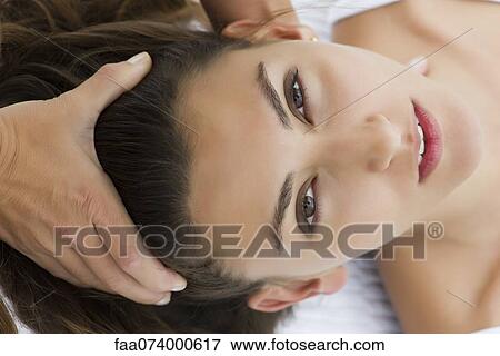 Stock Photo - Young woman receiving head massage. Fotosearch