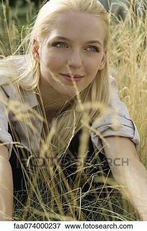 Young woman relaxing in tall grass, portrait View Large Photo Image Stock Photo - Young woman relaxing in tall grass, portrait. Fotosearch