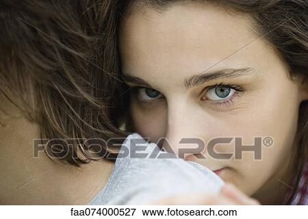 Stock Photo - Young woman resting head on boyfriend's shoulder, cropped portrait. Fotosearch