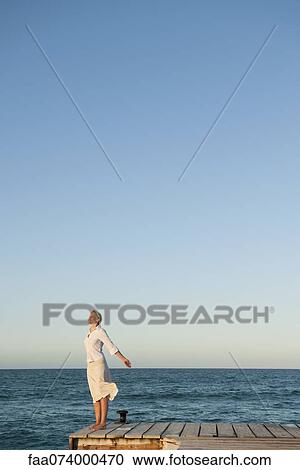 Young woman standing on pier with eyes closed View Large Photo Image Stock Image - Young woman standing on pier with eyes closed. Fotosearch