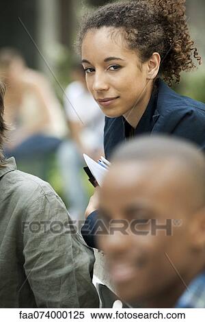 Young woman with friends, focus on one person View Large Photo Image Stock Photography - Young woman with friends, focus on one person. Fotosearch