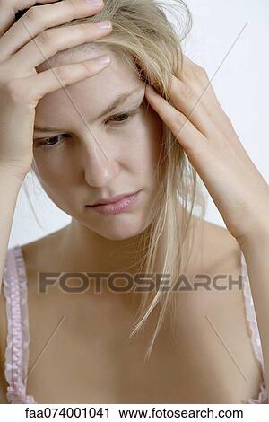 Stock Image - Young woman with hand on head. Fotosearch