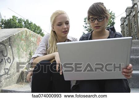 Young women using laptop computer outdoors View Large Photo Image Stock Image - Young women using laptop computer outdoors. Fotosearch