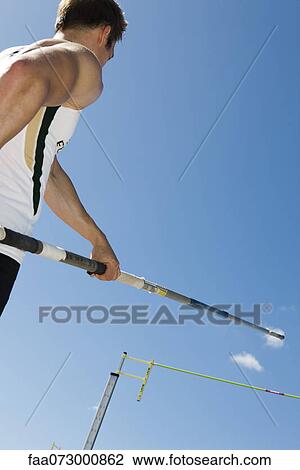 Athlete preparing for pole vault, low angle view View Large Photo Image Stock Image - Athlete preparing for pole vault, low angle view. Fotosearch