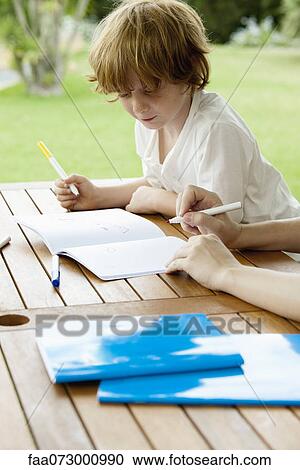 Stock Image - Boy coloring outdoors. Fotosearch