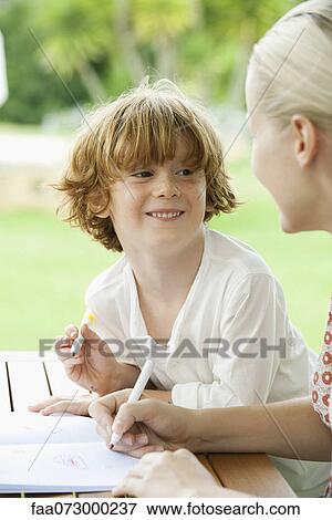 Boy coloring with his mother View Large Photo Image Stock Photo - Boy coloring with his mother. Fotosearch