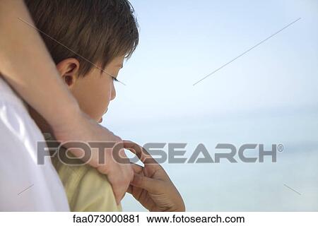 Stock Image - Boy holding mother's hand, cropped. Fotosearch