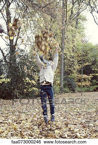 Boy jumping to reach tree branches with autumn leaves, blurred motion View Large Photo Image Stock Photograph - Boy jumping to reach tree branches with autumn leaves, blurred motion. Fotosearch