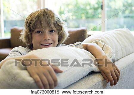 Boy leaning on sofa View Large Photo Image Stock Photography - Boy leaning on sofa. Fotosearch