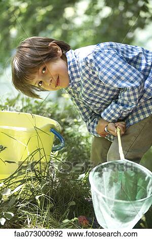 Boy leaning over bucket with fishing net in hands View Large Photo Image Stock Image - Boy leaning over bucket with fishing net in hands. Fotosearch
