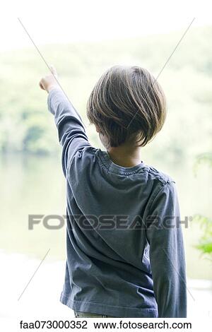 Boy looking at lake, pointing, rear view View Large Photo Image Stock Image - Boy looking at lake, pointing, rear view. Fotosearch