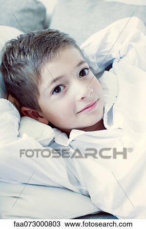 Boy lying on back with hands behind head, portrait View Large Photo Image Stock Image - Boy lying on back with hands behind head, portrait. Fotosearch