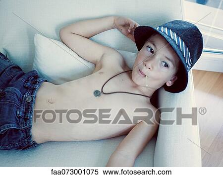 Boy lying on sofa, eating lollipop View Large Photo Image Stock Photography - Boy lying on sofa, eating lollipop. Fotosearch