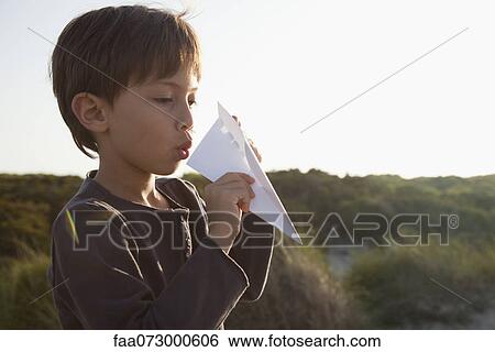 Boy making paper airplane View Large Photo Image Stock Photograph - Boy making paper airplane. Fotosearch