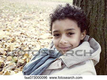 Boy outdoors in autumn, portrait View Large Photo Image Stock Photograph - Boy outdoors in autumn, portrait. Fotosearch