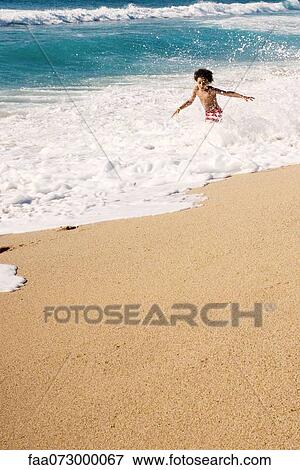 Boy playing in surf at the beach View Large Photo Image Stock Photo - Boy playing in surf at the beach. Fotosearch