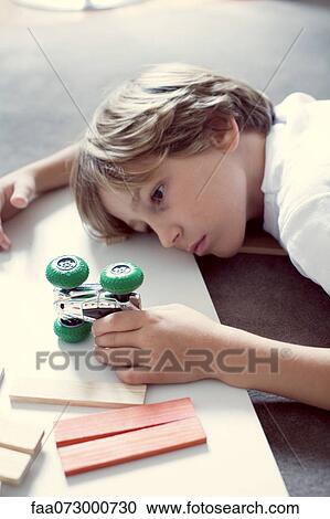 Stock Image - Boy playing with toy car. Fotosearch