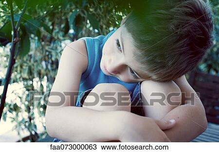Boy resting head on knees, daydreaming View Large Photo Image Stock Image - Boy resting head on knees, daydreaming. Fotosearch