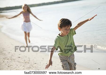 Boy running with arms out at the beach View Large Photo Image Stock Photo - Boy running with arms out at the beach. Fotosearch