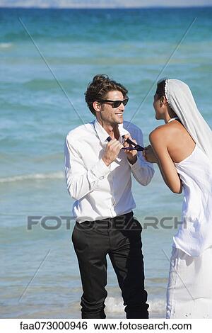 Stock Photograph - Bride and groom at the beach. Fotosearch