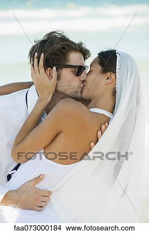 Bride and groom kissing at the beach View Large Photo Image Picture - Bride and groom kissing at the beach. Fotosearch