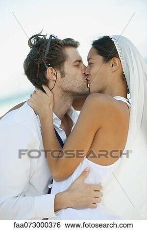 Stock Photograph - Bride and groom kissing. Fotosearch